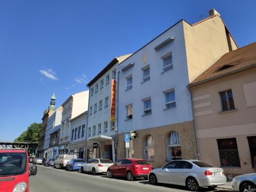 una fila di edifici su una strada con auto parcheggiate di Hotel Koruna a Roudnice nad Labem