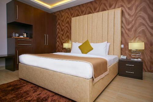 a large bed in a hotel room with two lamps at The Cabin Hotel in Accra