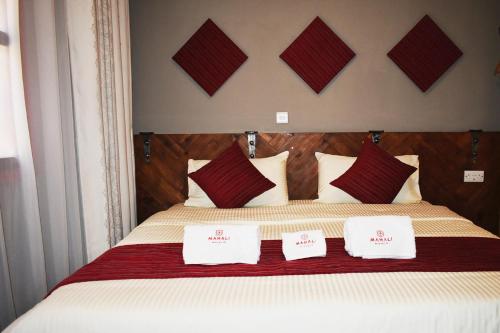 a bedroom with a large bed with red and white pillows at Mahali Guesthouse, Makindye Hill in Kampala
