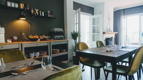 een eetkamer met een tafel en stoelen en een keuken bij Carmen Rooms -- Boutique B&B by the sea in Nerja