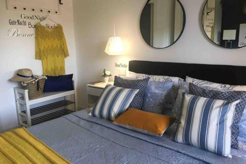 Un dormitorio con una cama con almohadas y un espejo. en PRIMA CLASSE, en Desenzano del Garda
