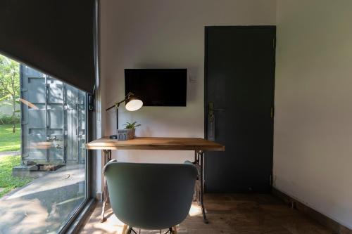 a desk and a chair in a room with a window at The Box House in Tangalle