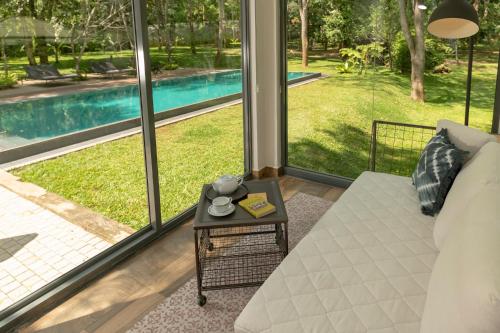 a living room with a view of a pool at The Box House in Tangalle