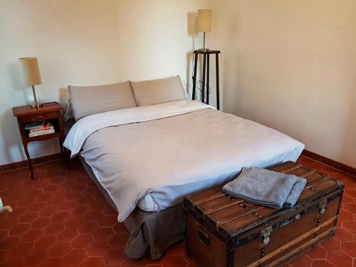 - une chambre avec un lit et un coffre ancien dans l'établissement 35m2 fonctionnel hyper-centre, à Ajaccio