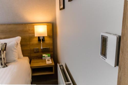 a bedroom with a bed and a tv on a wall at Holiday Inn Preston by IHG in Preston