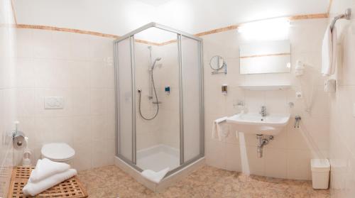 a bathroom with a shower and a toilet and a sink at Hotel Karl Schranz in Sankt Anton am Arlberg