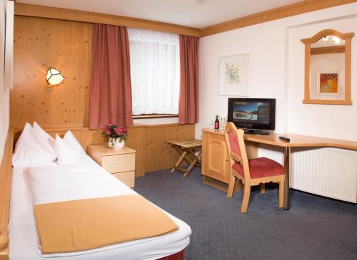 a hotel room with a bed and a desk at Hotel Karl Schranz in Sankt Anton am Arlberg