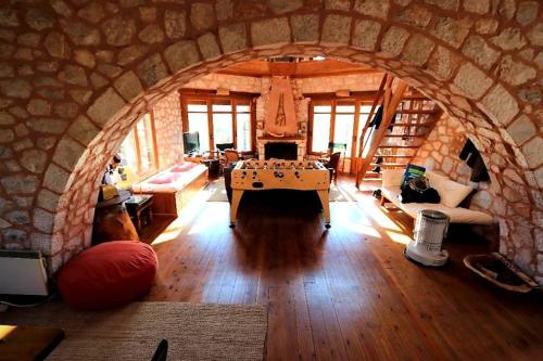 a living room with a stone archway with a pool table at Elati Hills in Vytina