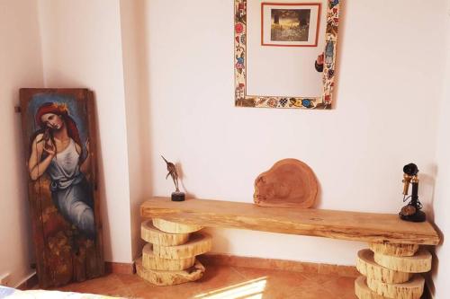 a wooden bench in a room with a painting on the wall at Elati Hills in Vytina