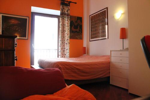 - une chambre avec des murs orange, un lit et une fenêtre dans l'établissement B&B&Courtesy, à Rome