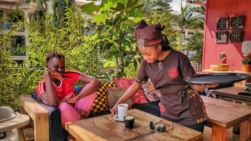 two women sitting at a table in a restaurant at Mahali Guesthouse, Makindye Hill in Kampala
