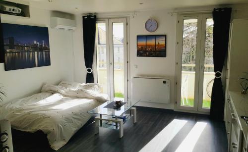 ポワシーにあるSuperbe studio de 30m2 proche de Parisのベッドとガラスのテーブルのある寝室