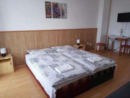 a bedroom with a large bed with two pillows on it at Napsugár Vendégház in Újudvar