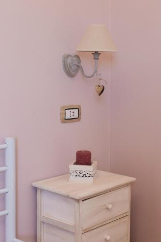 a table with a lamp and a clock on a wall at Alle Scalette B&B in Lauria