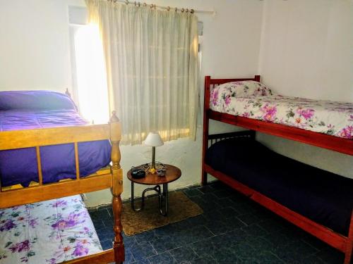 1 dormitorio con 2 literas y mesa con lámpara en Valle Encantado, en Monte Hermoso