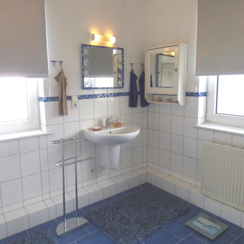 Gästezimmer im Hamburger Norden - nahe EuroFH und ILS في هامبورغ: حمام أبيض مع حوض ومرآة