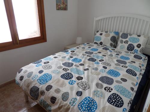 Appartement Cala Conills, Sant Elmo - WIFI gratis في سانت إلم: سرير لحاف ووسائد زرقاء وبيضاء