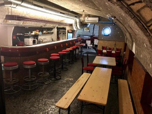 a bar with wooden tables and stools in a room at whole basement former pub 5 for Stag do in Budapest