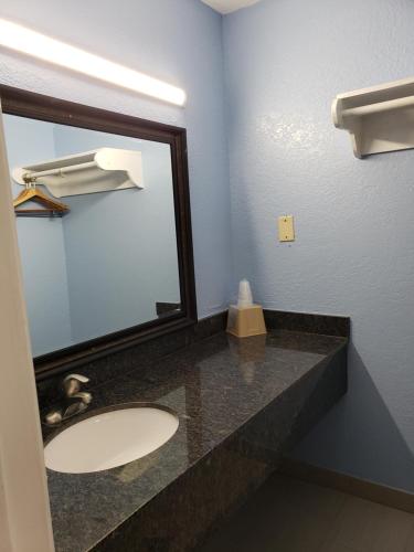 uma casa de banho com um lavatório e um espelho em Regency Inn Motel by the Beach em Corpus Christi