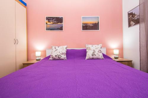 a purple bed in a room with two lamps at Rooms Biba in Dubrovnik