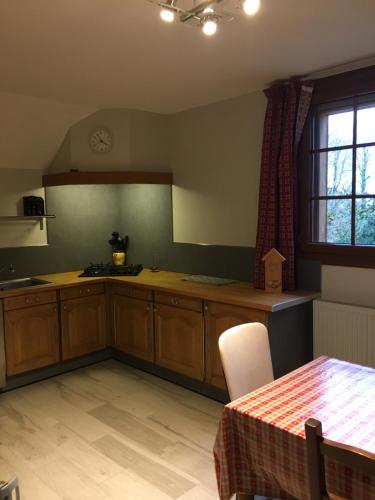 een keuken met houten kasten en een tafel en een raam bij villa des cascades du hérisson in Bonlieu