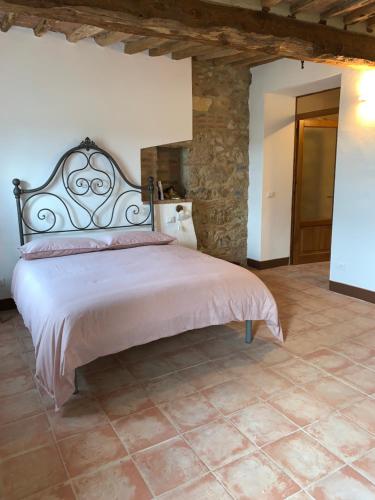 a bedroom with a large bed and a stone wall at Casa vacanza vicolo degli orti in Monticiano