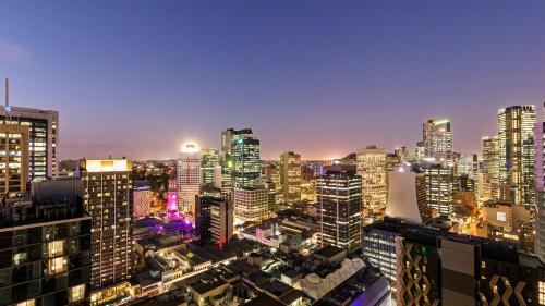 a city skyline at night with illuminated buildings at Oaks Brisbane Casino Tower Suites in Brisbane
