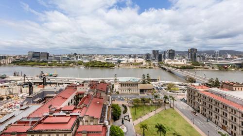 a city with a river and buildings and a bridge at Oaks Brisbane Casino Tower Suites in Brisbane