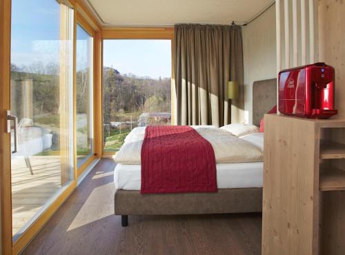 a bedroom with a bed and a large window at Bett in der Wies´n, Restaurant Triad in Bad Schönau