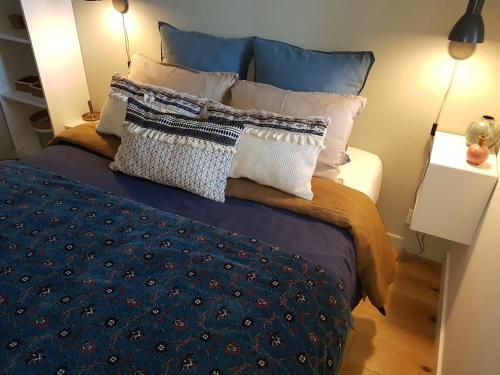 a bedroom with a bed with blue and white pillows at Fiquet de Normanville pour votre bien être en plein coeur historique in Rouen