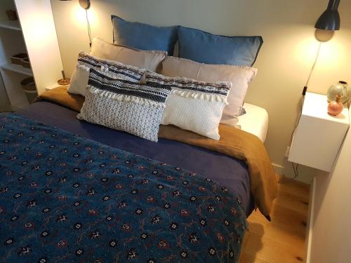 - une chambre avec un lit doté d'oreillers bleus et blancs dans l'établissement Fiquet de Normanville pour votre bien être en plein coeur historique, à Rouen