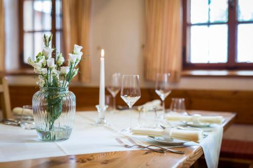 a table with a candle and flowers in a vase at Triad Wiener Alpen Bett DZ in Bad Schönau