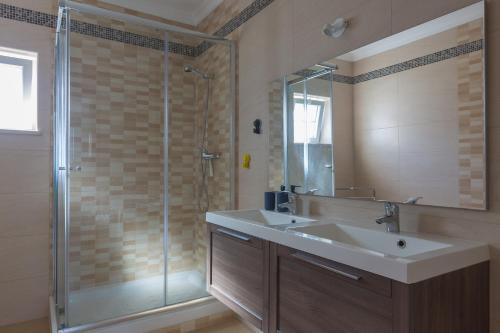 W łazience znajduje się umywalka i prysznic. w obiekcie Villa Coracao Jacuzzi - 200m Beach & Sea View w Albufeirze