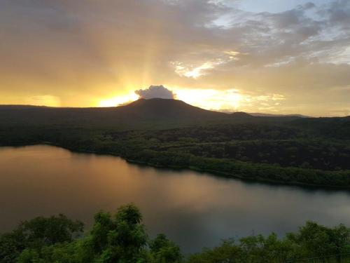 a sunset over a river with a mountain at Calalas Lodge in Nindirí