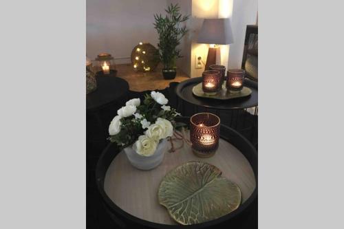 a living room with a table with flowers and candles at Cosy appartement ,Dinant, Abbaye de Maredsous in Anhée