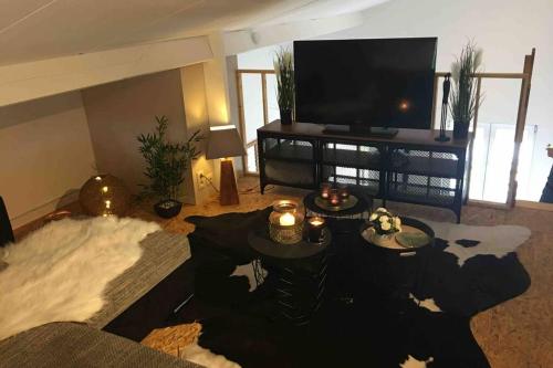 a living room with a flat screen tv and a couch at Cosy appartement ,Dinant, Abbaye de Maredsous in Anhée