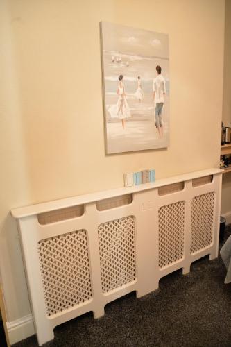 a painting hanging on a wall above a shelf at Lauriston & Lawton Court Hotel in Llandudno