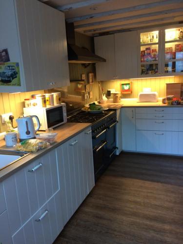a kitchen with white cabinets and a stove top oven at The Firs in Builth Wells
