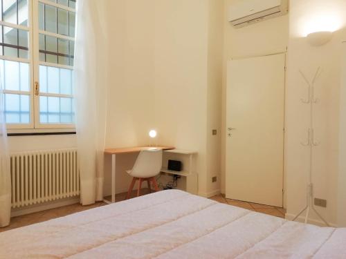 a bedroom with a bed and a table and a desk at MistrangeloHome 3 - Appartamento in Pieno Centro in Savona