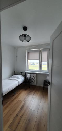 um quarto com uma cama e duas janelas em Apartament Północna przy Suntago, Deepspot em Mszczonów