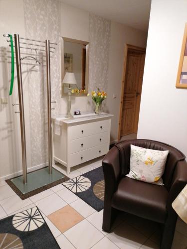 a bathroom with a chair and a mirror and a sink at Ferienwohnung Schmitz in Anschau