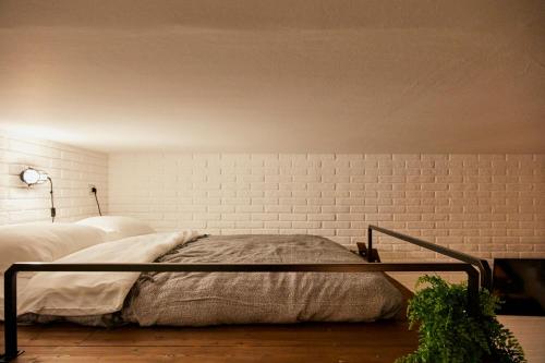 a bed in a bedroom with a brick wall at “Forte 99” in Venice in Mestre
