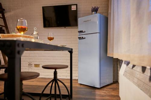 a white refrigerator in a kitchen with a table at “Forte 99” in Venice in Mestre