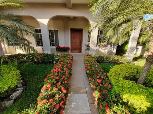a house with a garden with flowers and a walkway at Hotel Bethlehem in La Lima