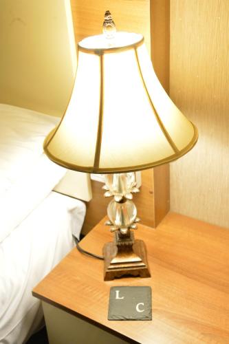 a lamp sitting on a table next to a bed at Lauriston & Lawton Court Hotel in Llandudno