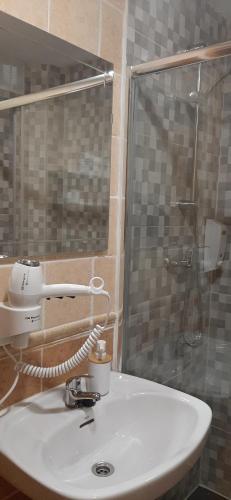 a bathroom with a white sink and a shower at Pensión CASA LEÓN in Santoña
