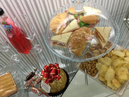 a table topped with two plates of sandwiches and chips at Maison De luxe in Pompei
