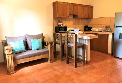 a kitchen with a couch and a table with a microwave at Hotel Casa Mangos Loreto in Loreto