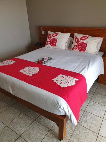 a bed with a red and white blanket on it at Tiki Hôtel - Hôtel d'application du Lycée de Tahiti in Punaauia
