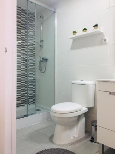 a white bathroom with a toilet and a shower at My Historic House 1 in Bragança